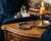 Un bracelet de pierres déposé sur une table de chevet, près d'une bougie