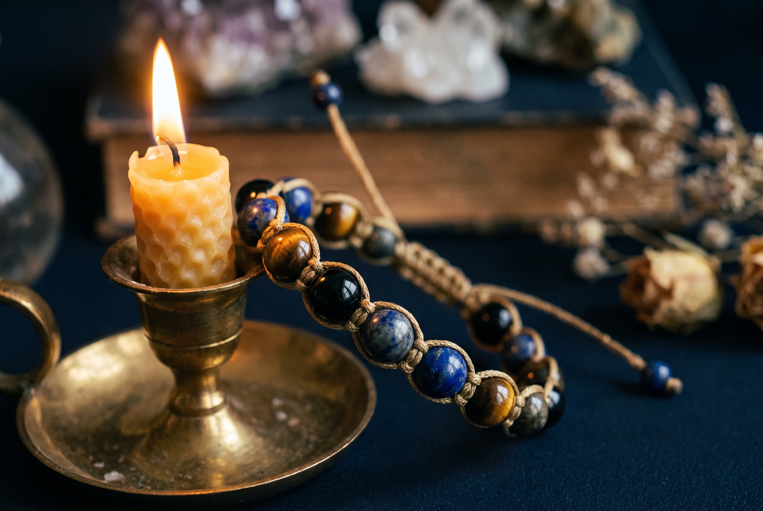 Un bracelet shamballa et ses perles, éclairés à la lueur d'une bougie