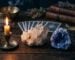 Amas de quartz et geode pres d une bougie sur une table en bois sombre, clair de lune diffus